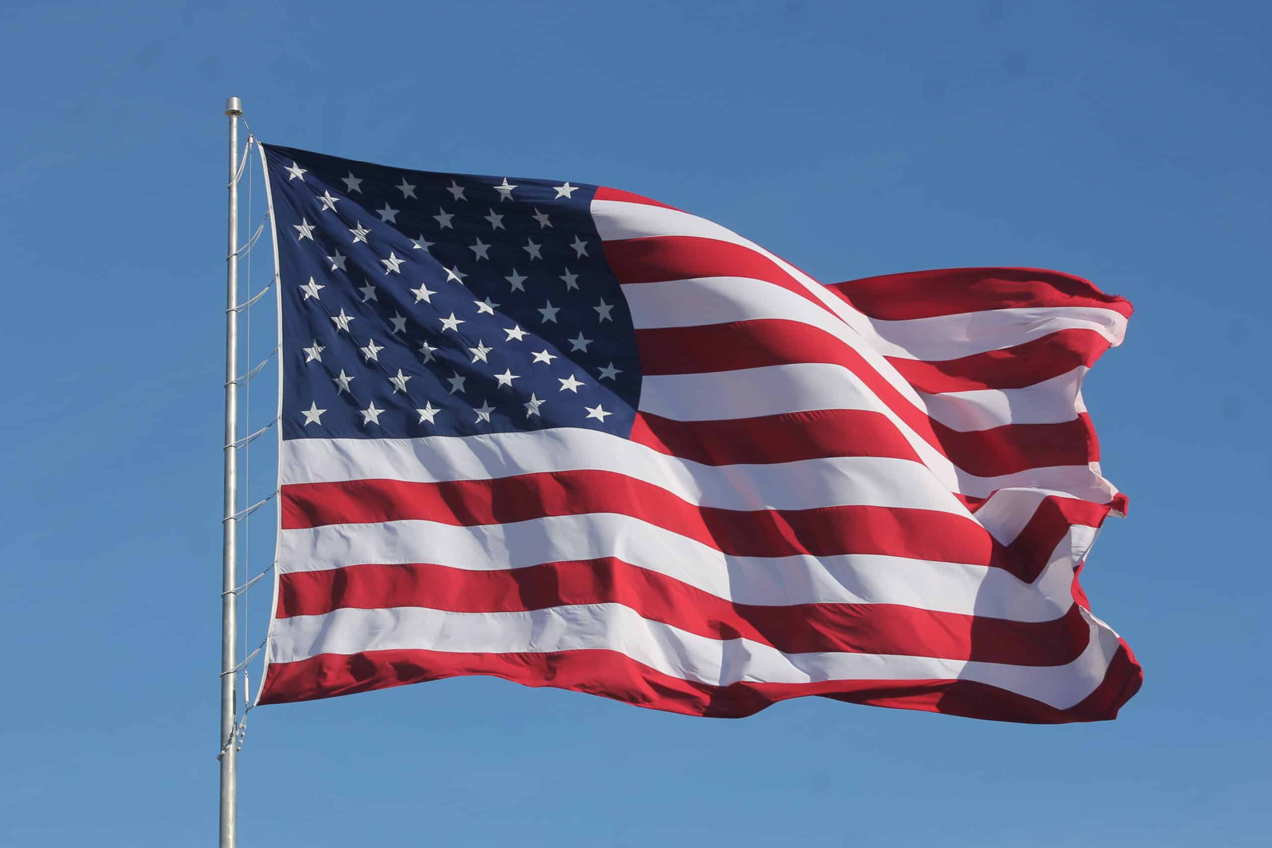American flag waves in blue sky